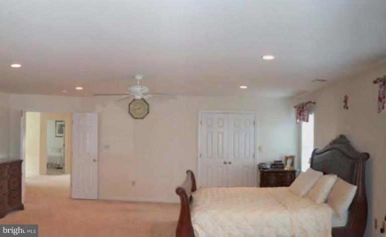 6089 Deer Ridge Trail Springfield, VA 22150 - Photo 16 of 30 a bedroom with a bed and a chandelier