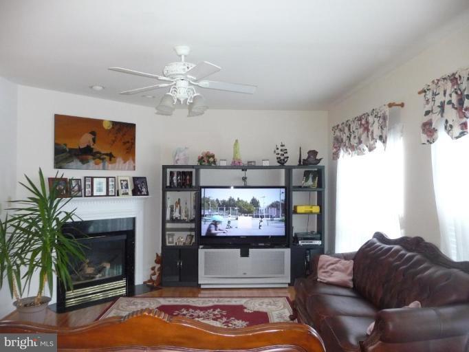 6089 Deer Ridge Trail Springfield, VA 22150 - Photo 7 of 30 a living room with furniture a flat screen tv and a fireplace