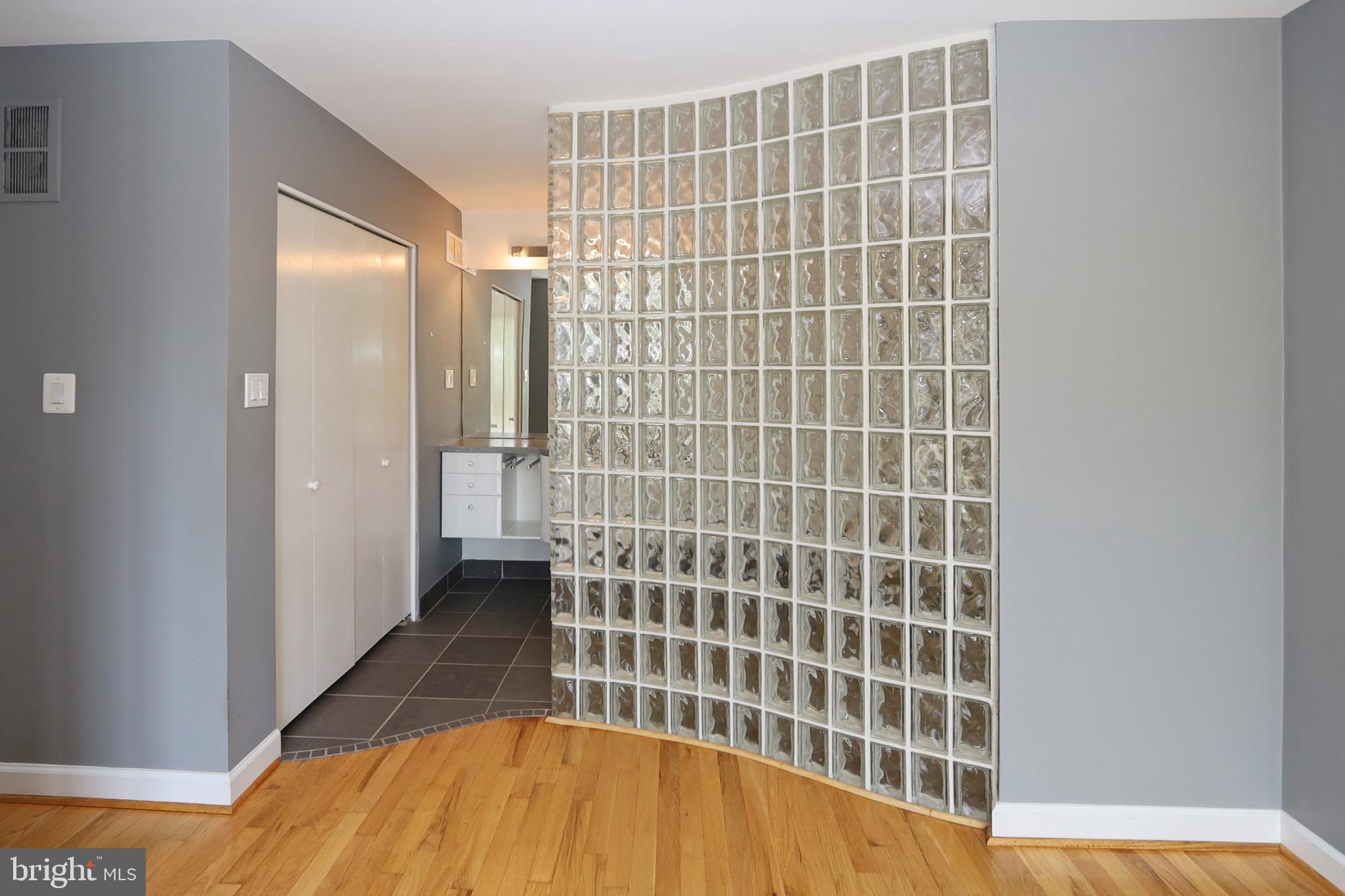 1682 Chimney House Road Reston, VA 20190 - Photo 27 of 56 Curved glass block wall leads to the primary bath