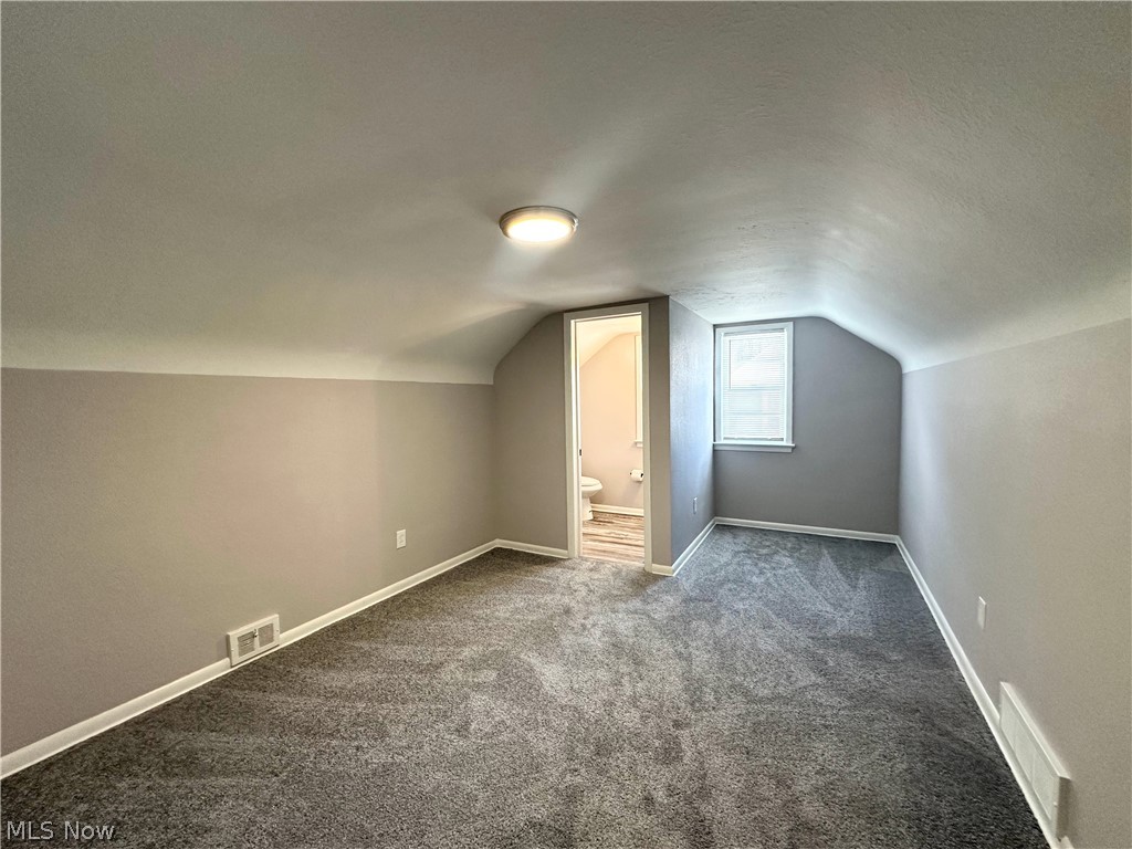 2440 Dentzler Road Parma, OH 44134 - Photo 5 of 11 Additional living space featuring dark colored carpet and a textured ceiling