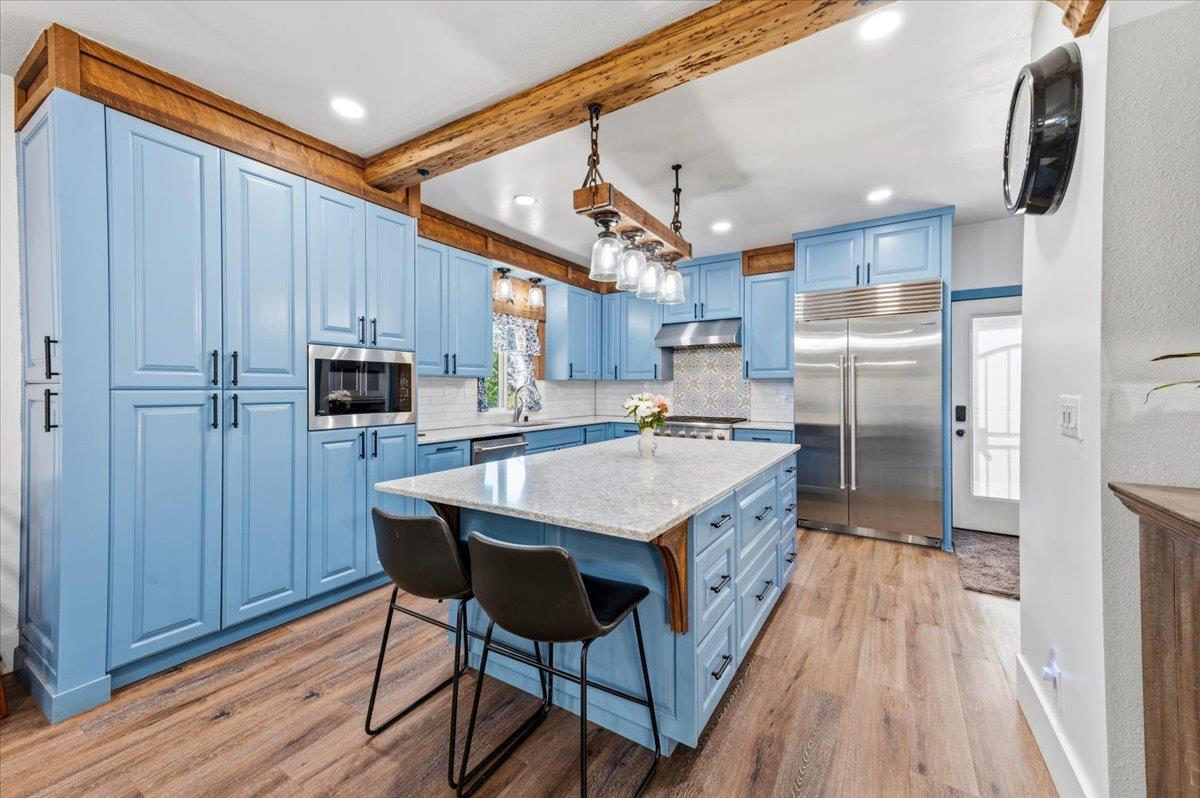 10784 Cole Way Grass Valley, CA 95945 - Photo 11 of 57 a kitchen with kitchen island granite countertop wooden floors and stainless steel appliances