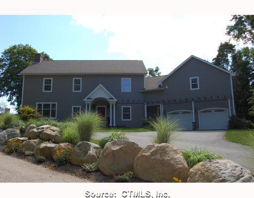 a front view of house with yard and trees around