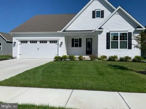 a front view of a house with a garden and yard