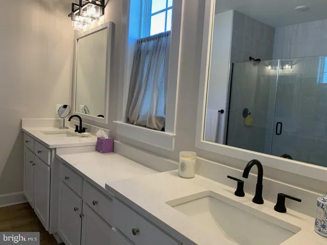 a bathroom with double sink and a mirror