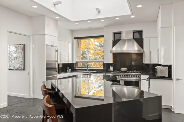 a kitchen with stainless steel appliances granite countertop a stove top oven a sink a counter top space and cabinets