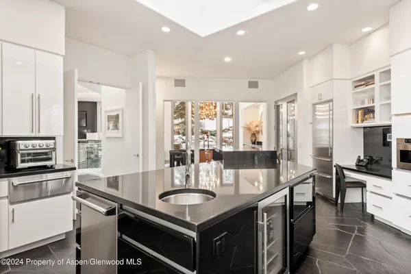 a large kitchen with kitchen island granite countertop a sink and stainless steel appliances
