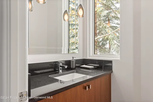 a bathroom with a granite countertop sink and a window