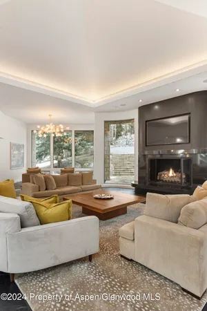 a living room with fireplace furniture and a large window