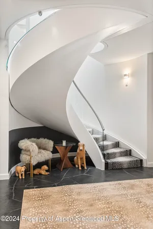 a spacious bedroom with a bed and glass walk in closet