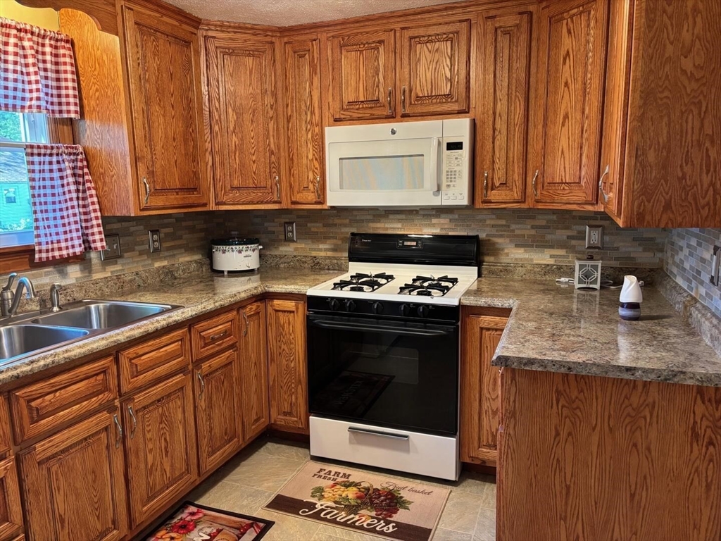 65 Brookside Circle Springfield, MA 01129 - Photo 9 of 25 a kitchen with stainless steel appliances granite countertop wooden cabinets a stove and a sink