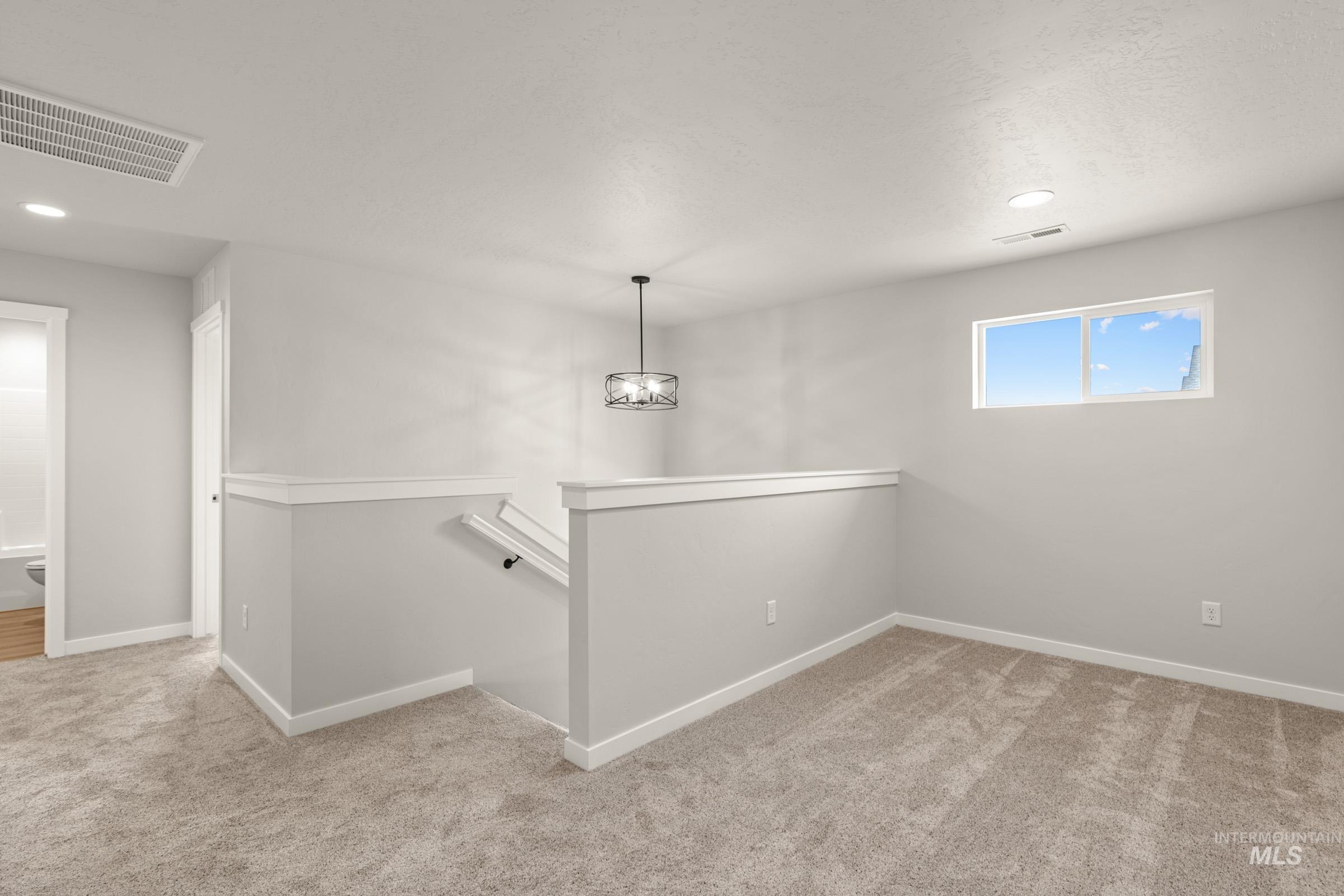 13704 Redway Court Caldwell, ID 83607 - Photo 15 of 23 Corridor featuring carpet floors, suspended lighting, and an upstairs landing