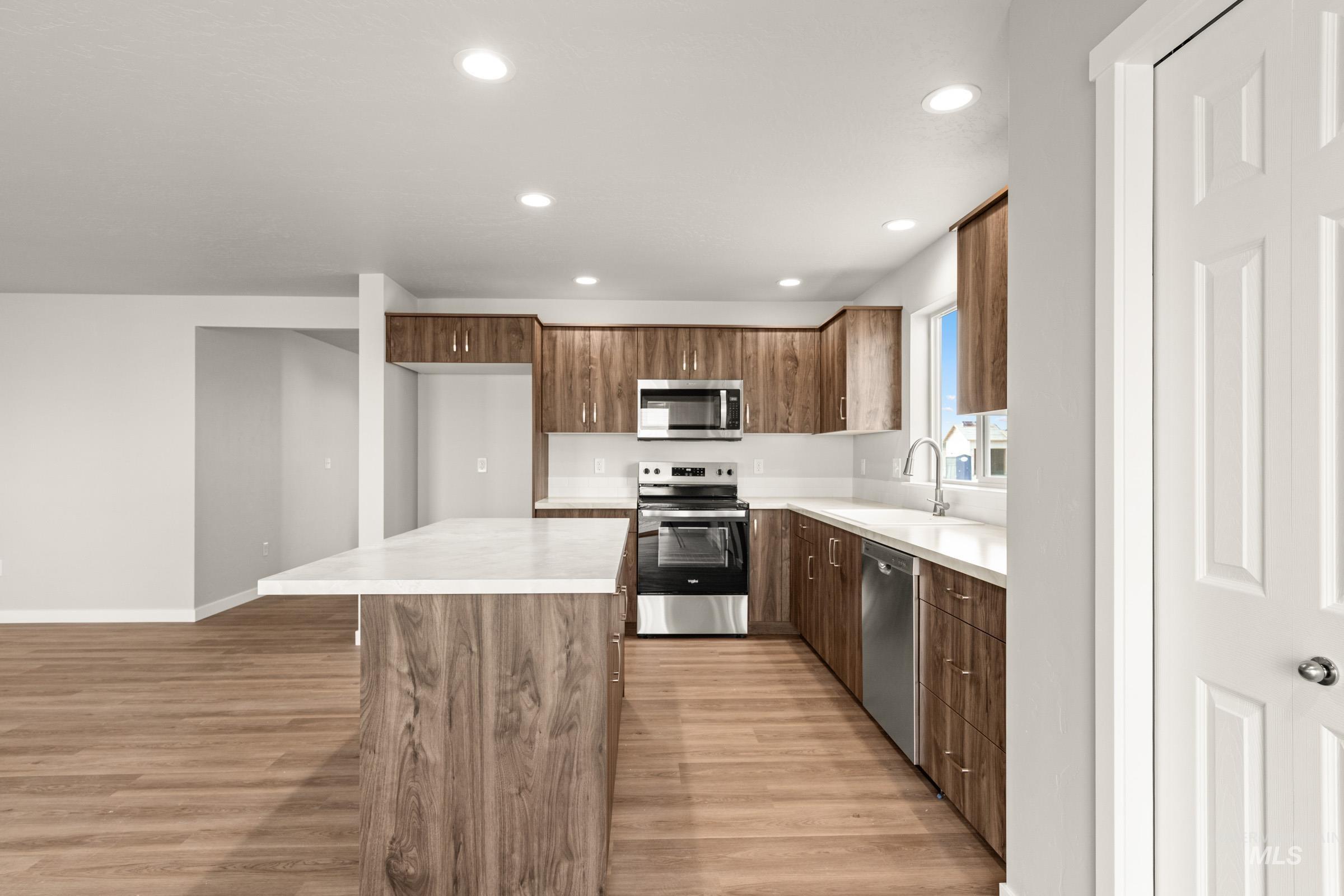 13704 Redway Court Caldwell, ID 83607 - Photo 5 of 23 Kitchen with light countertops, stainless steel appliances, light wood-style flooring, recessed lighting, and a center island