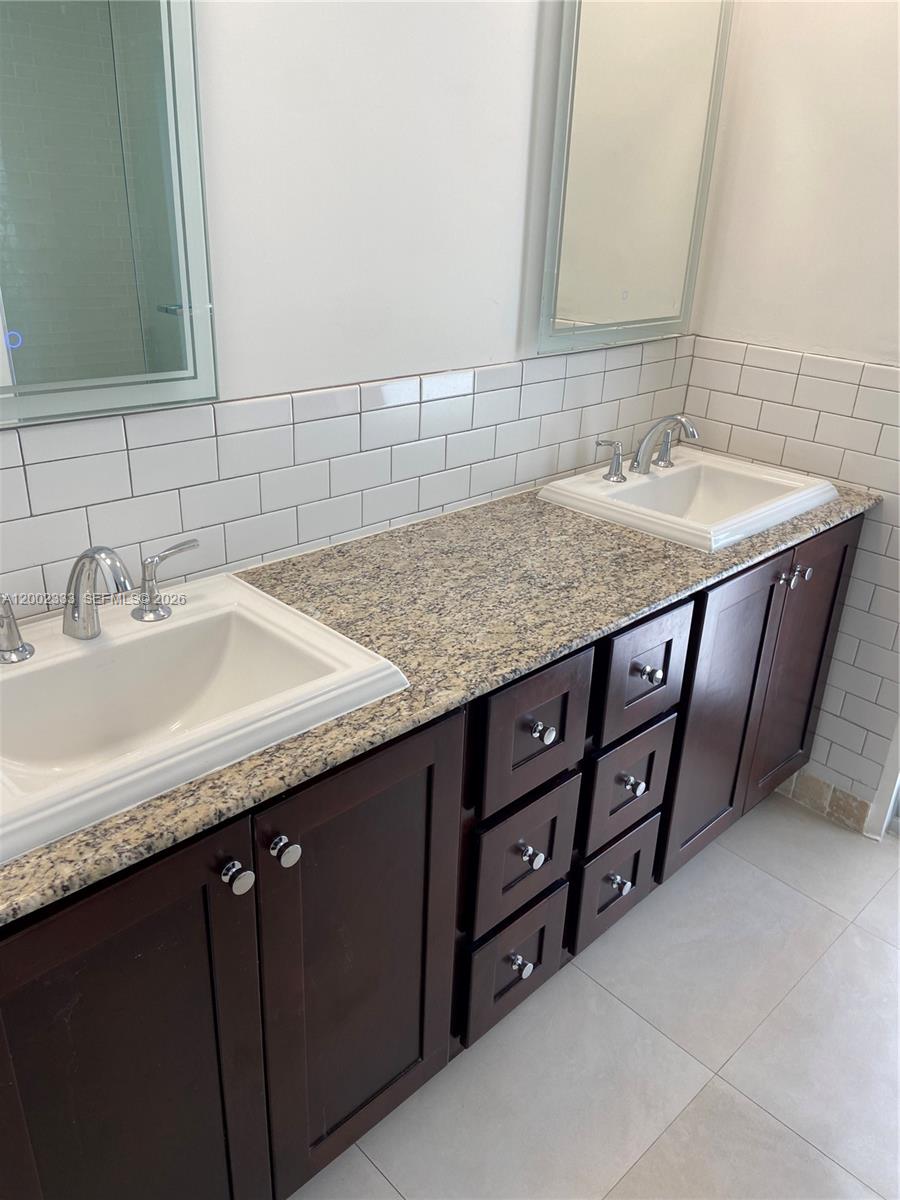 9840 Southwest 69th Avenue Pinecrest, FL 33156 - Photo 15 of 24 a bathroom with a granite countertop sink and a mirror