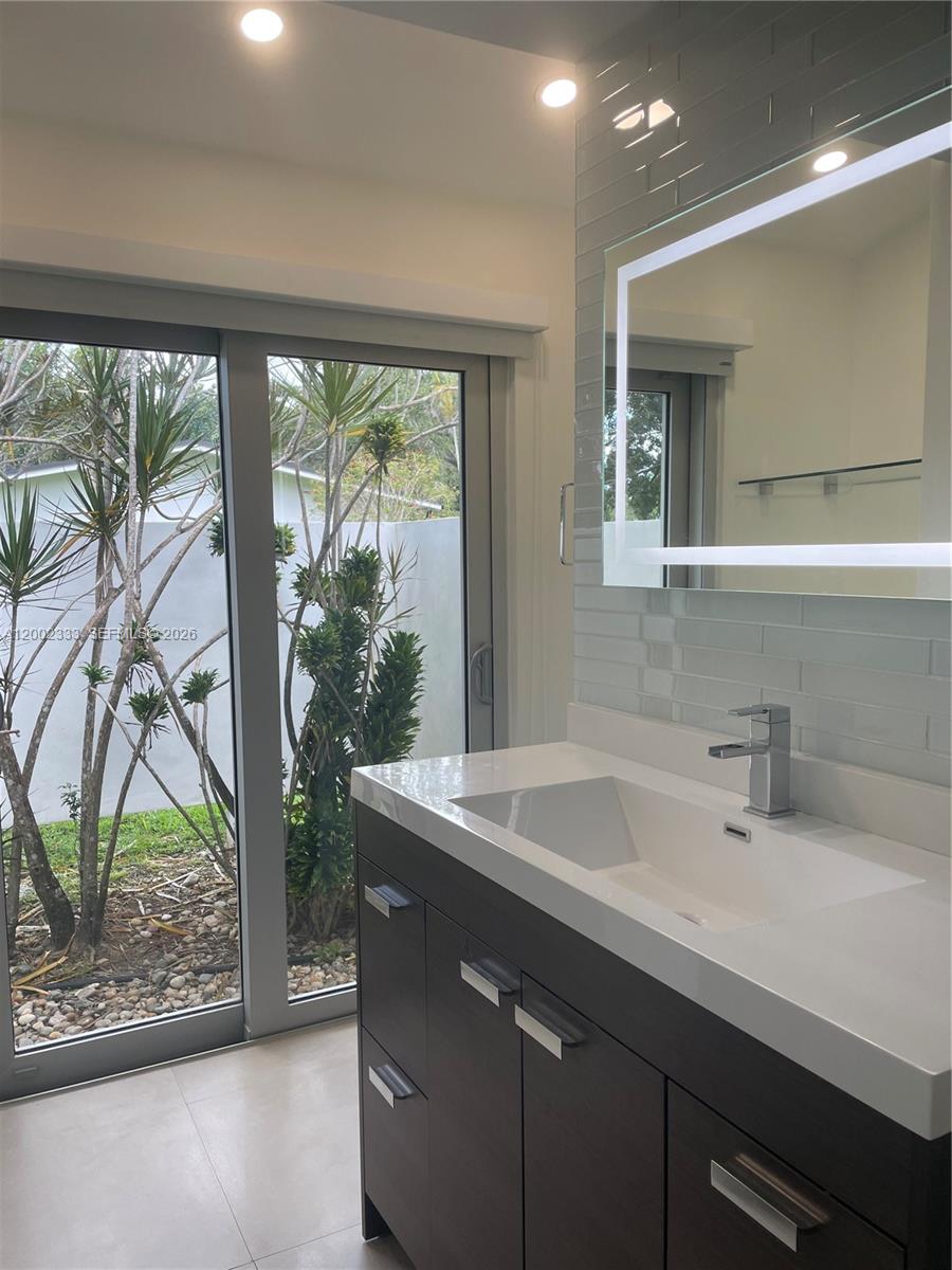 9840 Southwest 69th Avenue Pinecrest, FL 33156 - Photo 7 of 24 a sink with a large mirror next to a yard