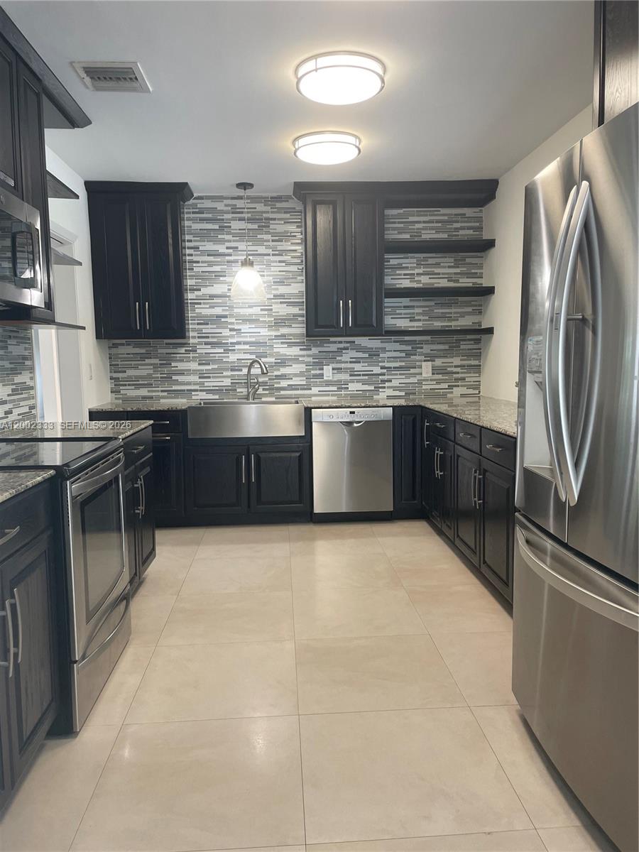 9840 Southwest 69th Avenue Pinecrest, FL 33156 - Photo 9 of 24 a large kitchen with cabinets and stainless steel appliances