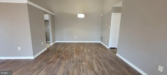 a view of a room with wooden floor and a ceiling fan