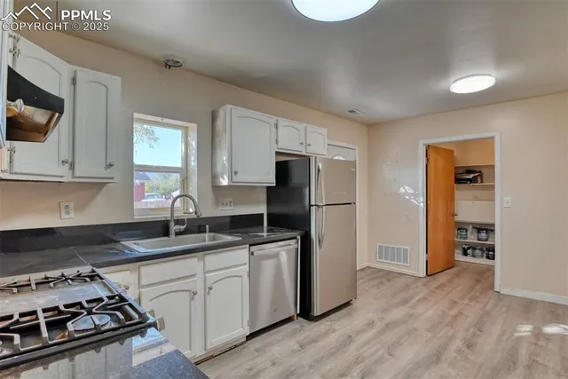 a kitchen with stainless steel appliances granite countertop a sink stove refrigerator and microwave