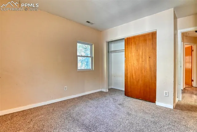 an empty room with windows and closet