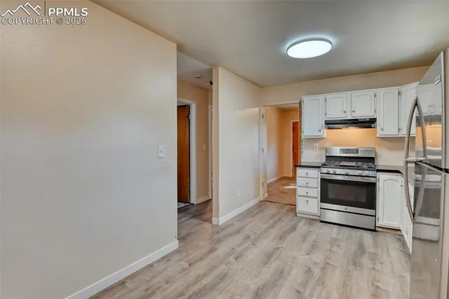 a kitchen with granite countertop a stove and a refrigerator