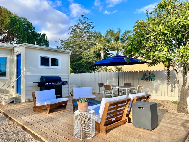 a roof deck with table and chairs under an umbrella with trees
