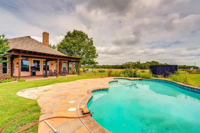 a view of a house with swimming pool and a yard
