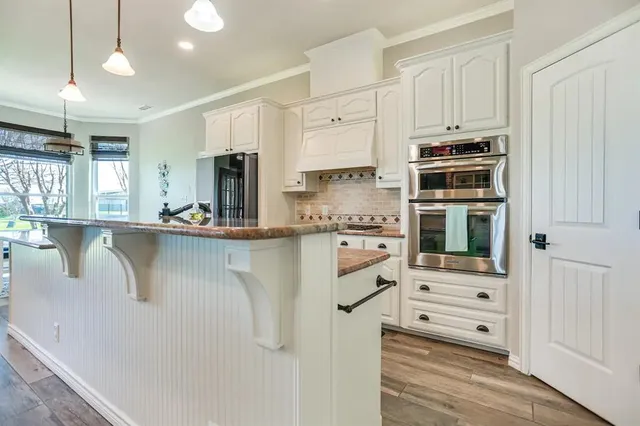 a kitchen with stainless steel appliances granite countertop a refrigerator and a stove top oven