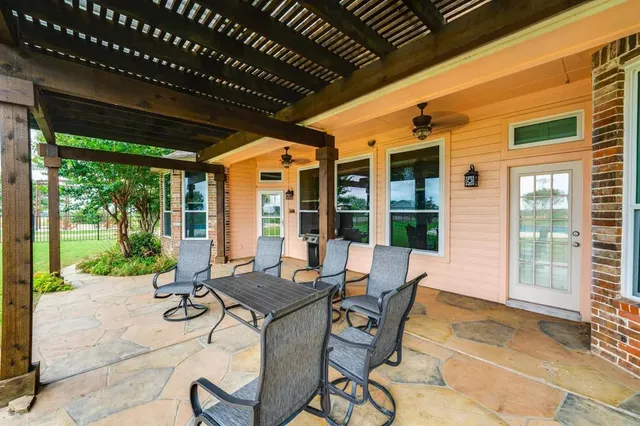 a view of a patio with table and chairs and potted plants