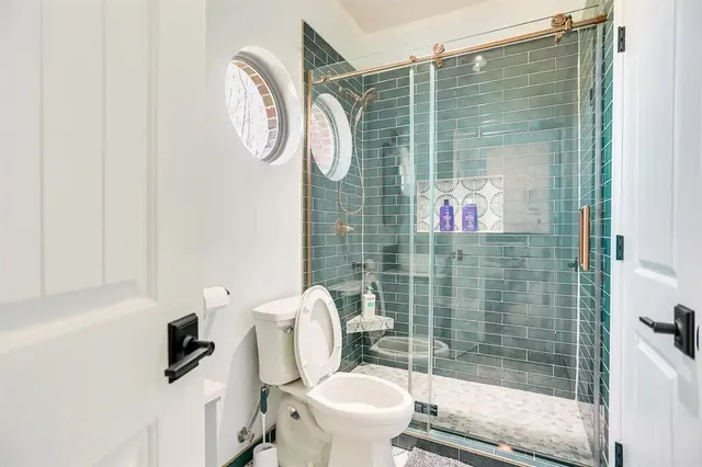 a bathroom with a toilet and a shower