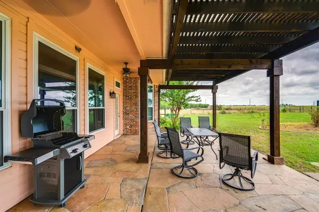 a view of a porch with furniture and floor to ceiling window