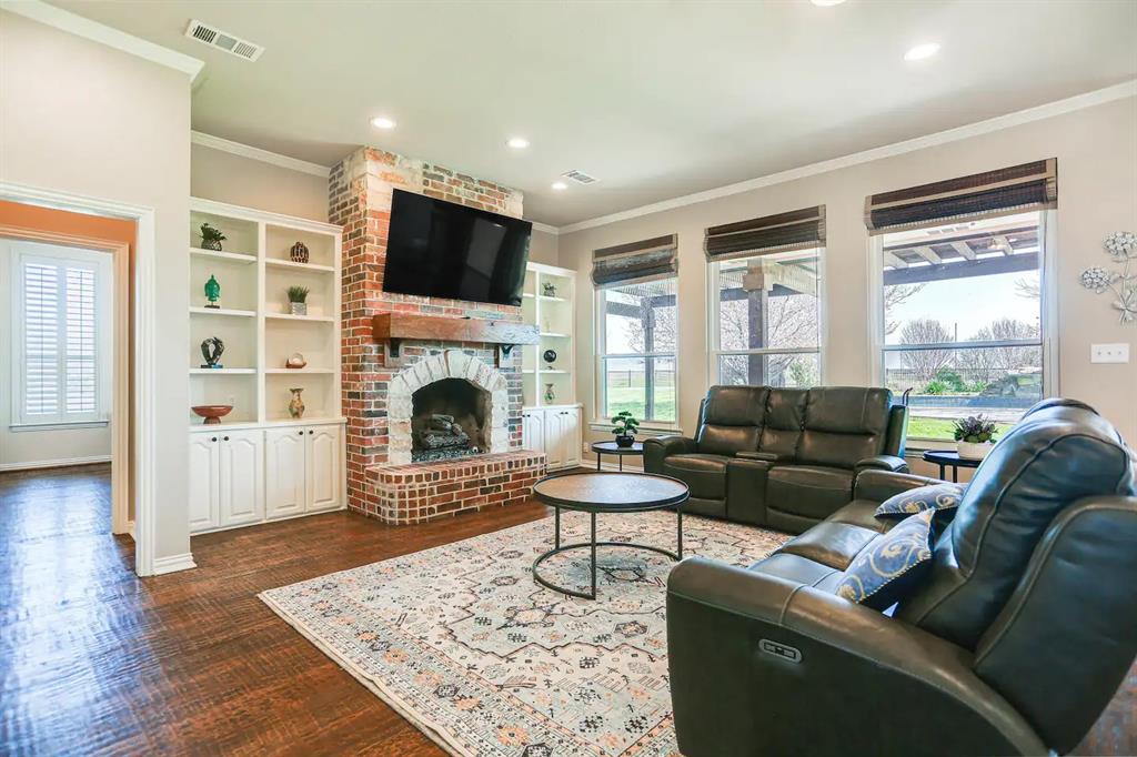 2045 Weston Road McKinney, TX 75071 - Photo 3 of 40 a living room with furniture a flat screen tv and a fireplace