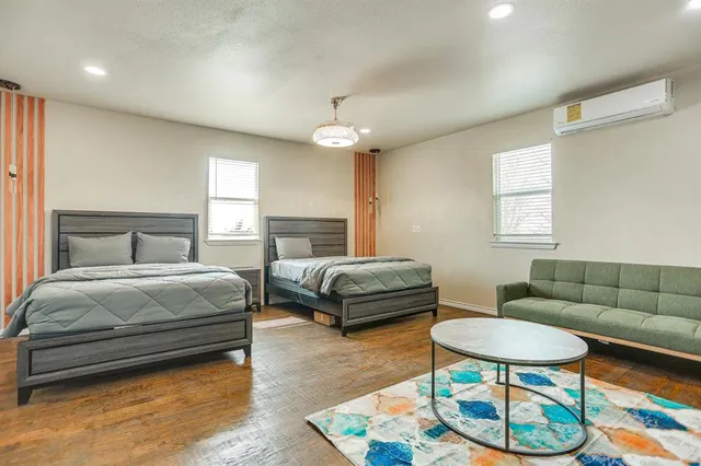 a bedroom with a bed a couch and a chandelier
