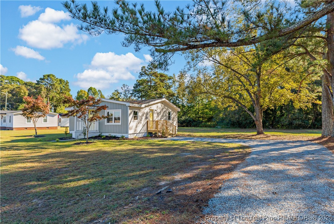 1340 George Perry Lee Road Dunn, NC 28334 - Photo 8 of 31 a front view of a house with a yard and trees
