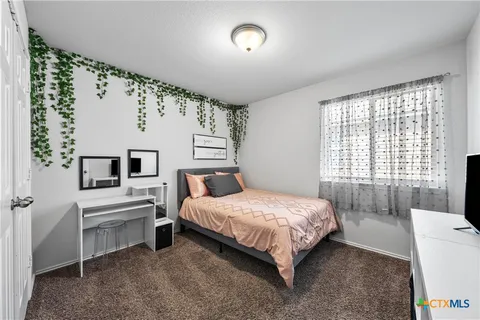 a bedroom with a bed and a large window
