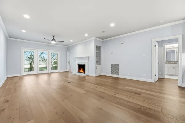 an empty room with windows and fireplace