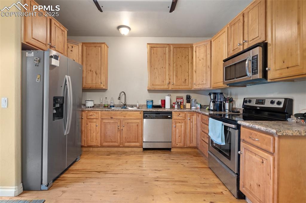 1510 York Road, Unit 101 Colorado Springs, CO 80918 - Photo 6 of 12 a kitchen with stainless steel appliances granite countertop a refrigerator sink and cabinets