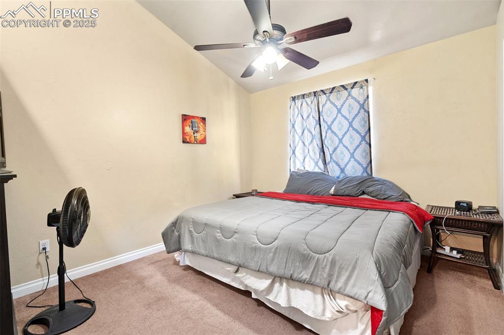 1510 York Road, Unit 101 Colorado Springs, CO 80918 - Photo 8 of 12 a bedroom with a bed and a chandelier