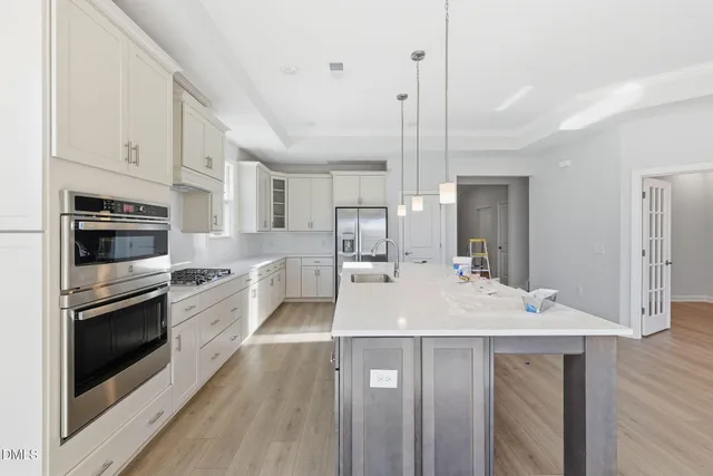 a large kitchen with kitchen island a sink stainless steel appliances and cabinets