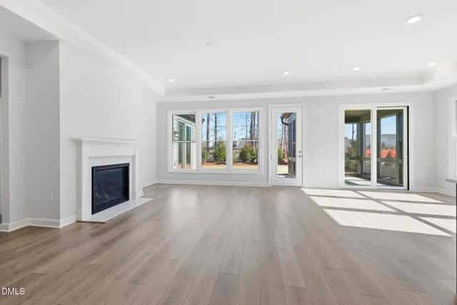 wooden floor fireplace and windows in an empty room
