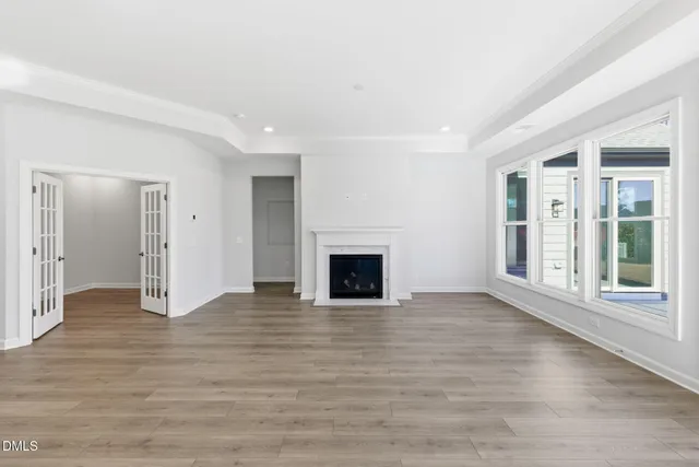 a view of a livingroom with wooden floor and a fireplace
