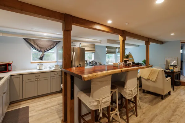 a living room with stainless steel appliances kitchen island granite countertop furniture and a large window