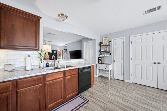 a large kitchen with a lot of counter space and wooden floor