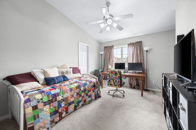 a bedroom with bed and a flat tv screen on dresser