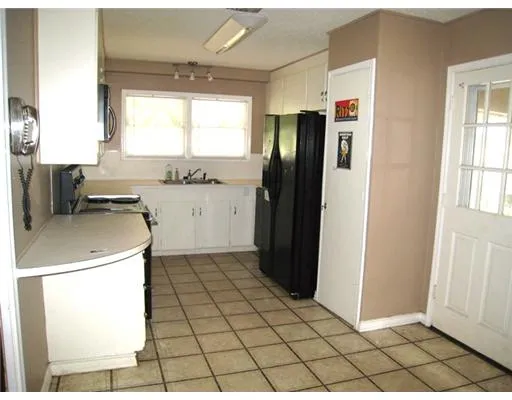 a kitchen with a sink a refrigerator and cabinets