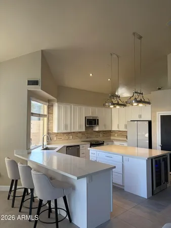 a kitchen with kitchen island granite countertop a stove top oven a sink a counter space and cabinets