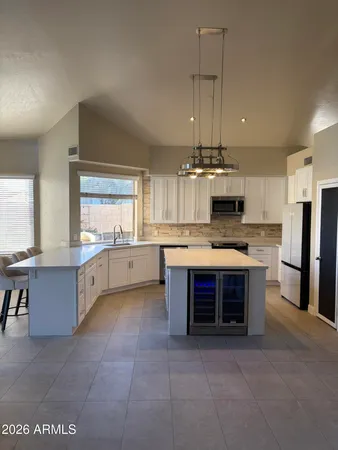a large kitchen with stainless steel appliances granite countertop a stove and a sink