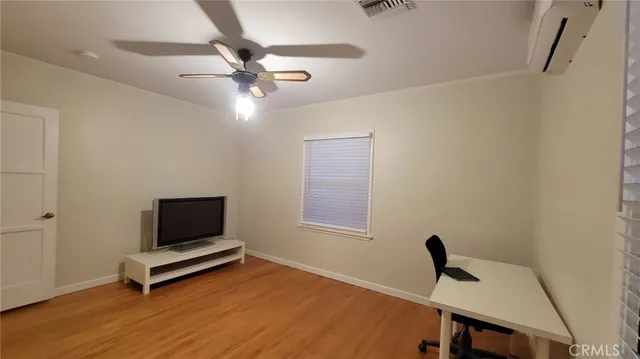 a view of a workspace with wooden floor and a window