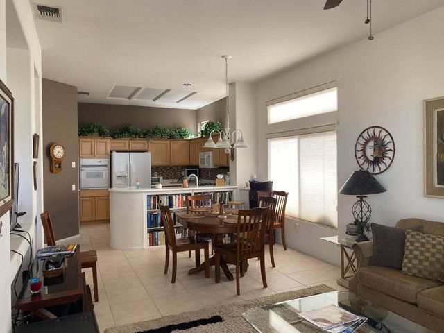 a view of a dining room and livingroom with furniture a rug a fireplace and a chandelier