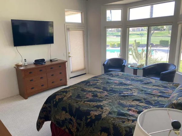 a bedroom with a bed and a television