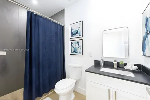 a bathroom with a granite countertop sink toilet a mirror and shower
