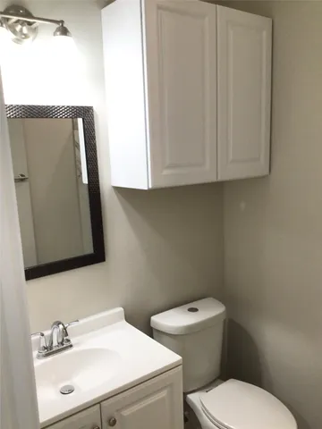 a bathroom with a toilet sink and mirror